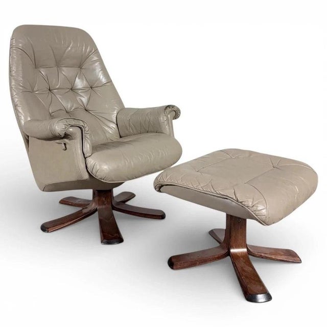 A classic Swedish Stressless leather recliner with its matching footstool, combining ergonomic comfort with a sculpted...