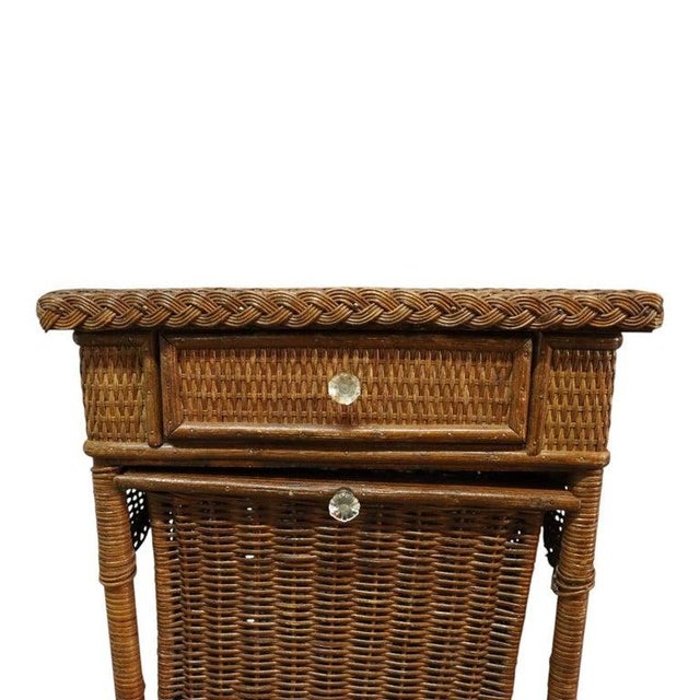 This antique sewing stand, attributed to Heywood Wakefield, is crafted from woven wicker and dates to approximately 1920....