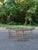A stylish vintage oval coffee table inspired by classic faux bamboo designs, featuring a sculptural resin base with an...