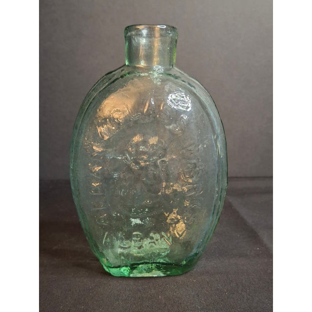 This rare, authentic early American historical flask features an aqua green blown-molded body produced by the Albany Glass...