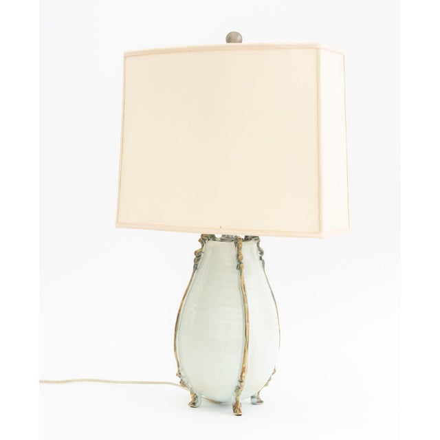 Celadon Glazed Art Pottery Vase Mounted as a Lamp, on four hoof form feet. Overall: 23.5" H x 14.5" W x 9" D. Provenance:...