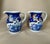 A pair of decorative ceramic jugs/pitchers finished in a deep cobalt blue with blue-and-white illustration and gilt...