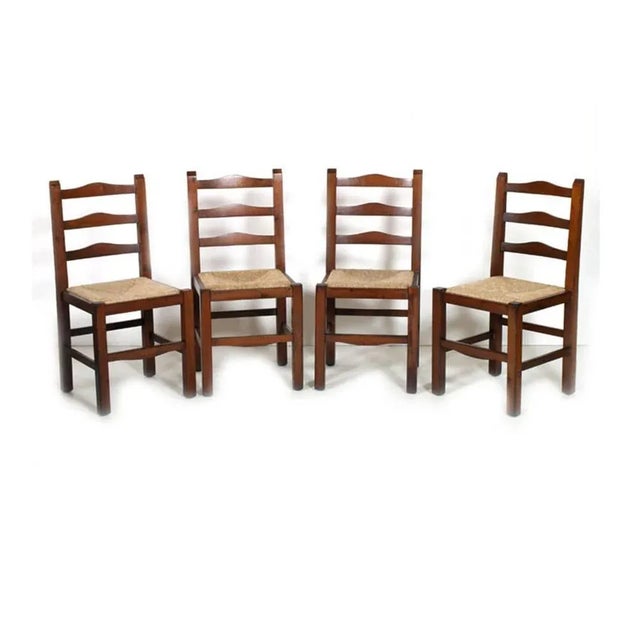 This set of four rustic chairs in chestnut has been polished with wax. The seats are made of straw.