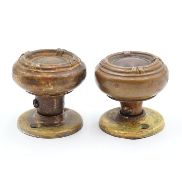 Set of two antique Louis XIV style dummy door knobs with plain brass rosettes and brass knobs featuring stepped circular...