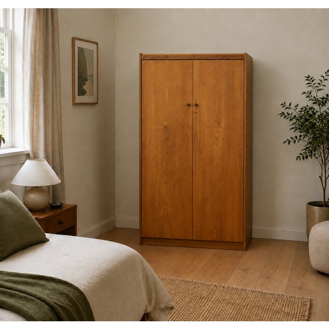 A 1960s mid-century double wardrobe in warm teak veneer, featuring clean lines, wooden handles and subtle segmented...