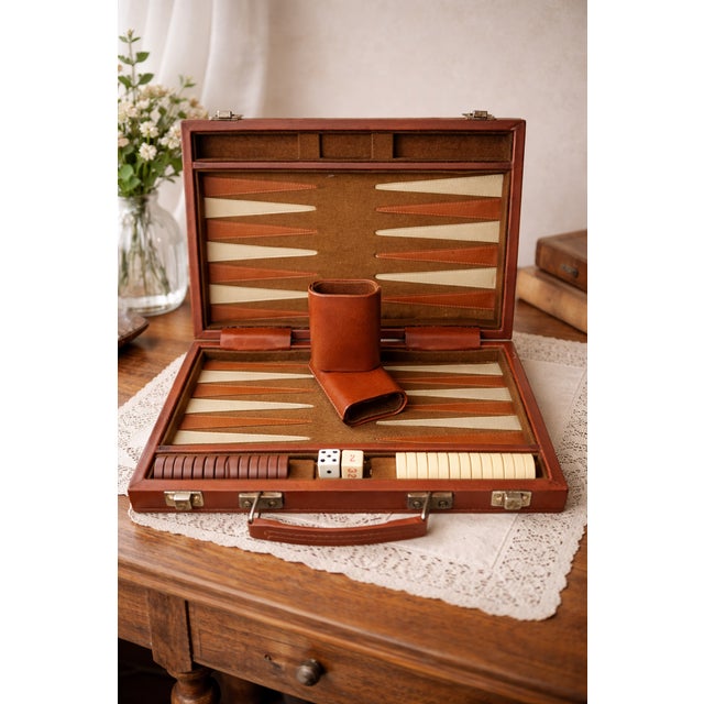 Vintage backgammon set housed in a classic brown faux leather carrying case with decorative darker brown stripes. This...