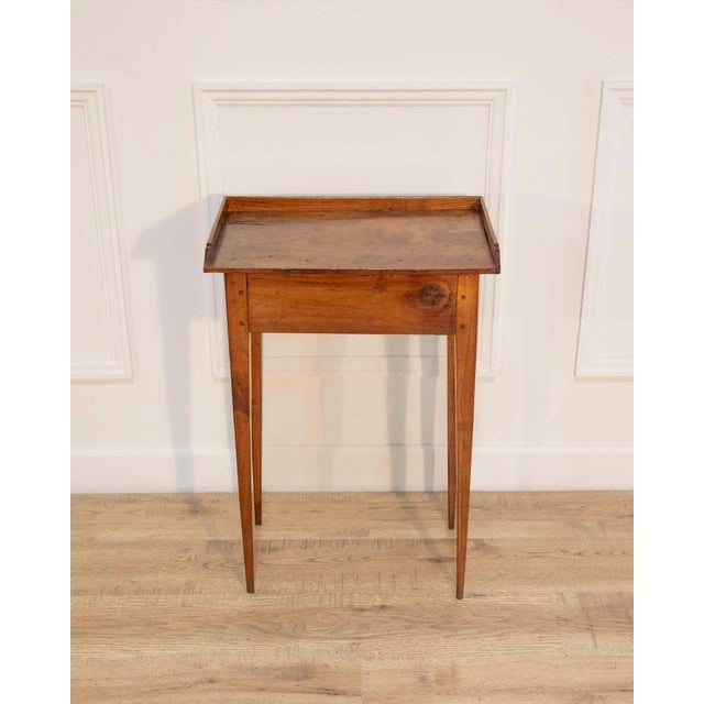 A refined Louis XVI–style side table crafted in walnut, notable for its clean neoclassical lines and honest, time-earned...