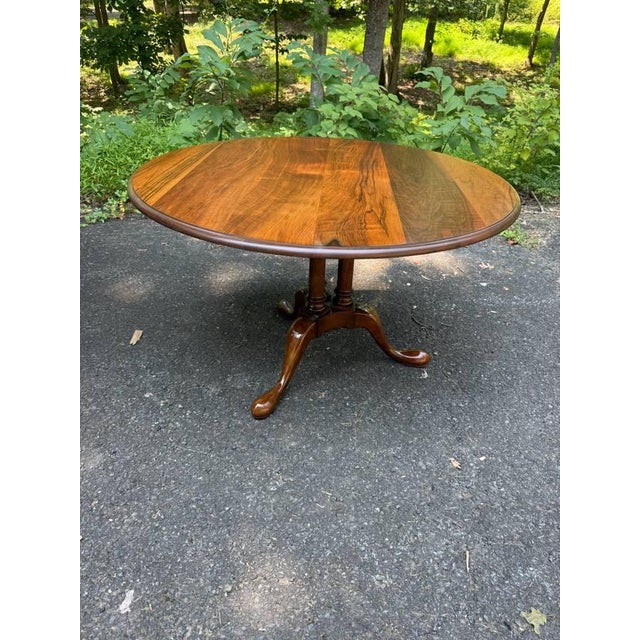 Georgian style pedestal center table by Baker It features turned pedestal base and a tripod base with pad or snake feet....
