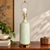 Elegant vintage Mid-Century table lamp featuring a tall, gently tapered ceramic body finished in a luminous pale celadon...