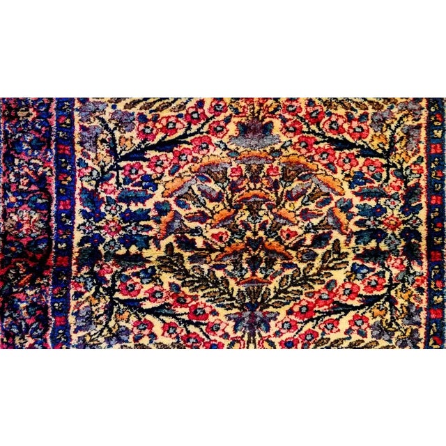 A wonderful early 20th century Persian Kirman rug with a densely woven mirrored floral and leaf pattern woven in indigo,...