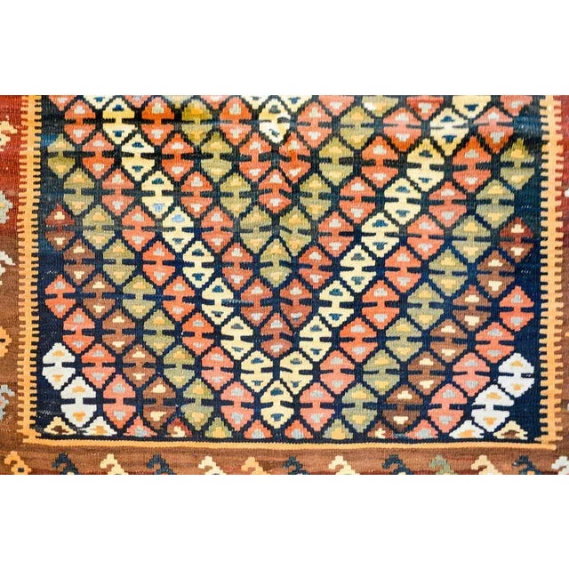An early 20th century Persian Ersin Kilim rug with intricately woven diamond pattern on a black background. The border is...