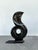 A bold sculptural stone piece defined by fluid movement and architectural form, this abstract composition features a...