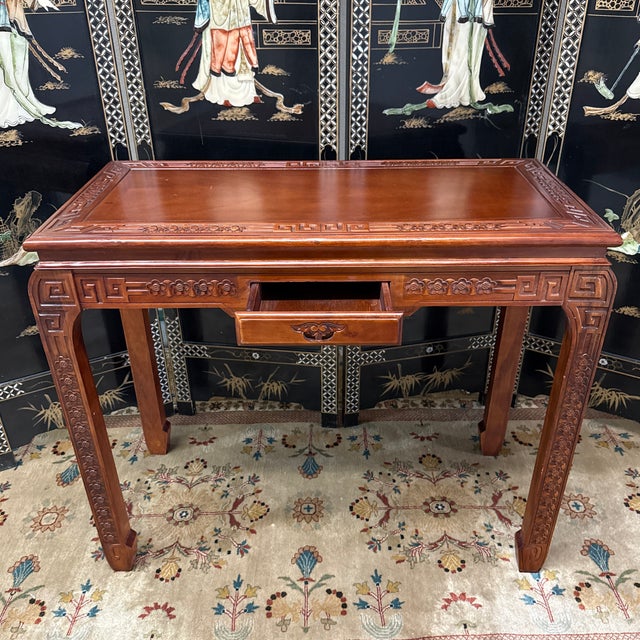 Design Plus Gallery presents a Vintage Asian Carved Hardwood Writing Desk. The rectangular top is bordered by carved...