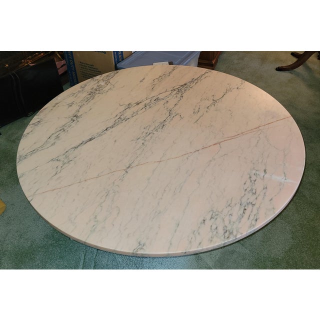 A mid-century pale pink round Italian marble top is set on an octagonal wood pedestal base, painted cream with gold trim....