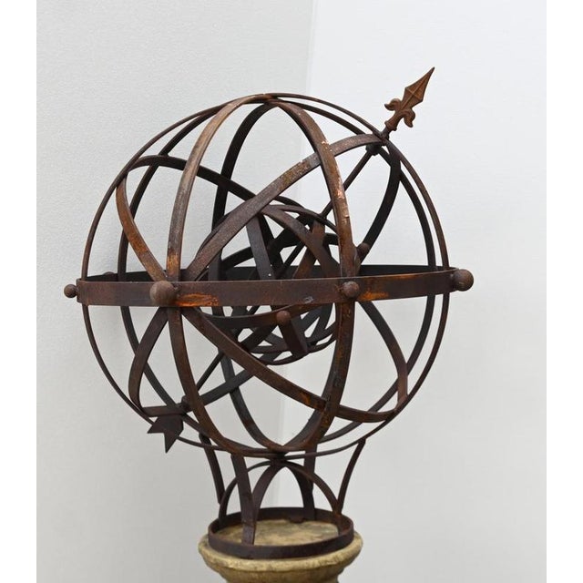 An impressive garden armillary sphere mounted upon a substantial classical-style stone pedestal The openwork iron sphere...