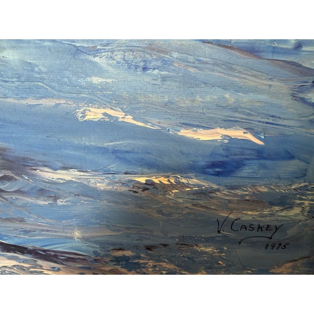This original oil painting by V. Caskey, dated 1975, captures a peaceful coastal harbor lined with weathered waterfront...
