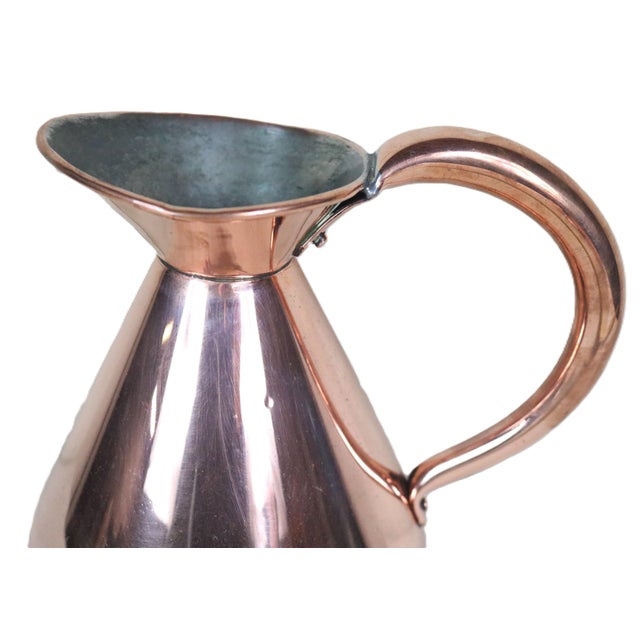 A traditional English copper liquid measure with a 1/2 gallon volume dating from the late 19th century. This shape is...