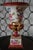 A striking vintage porcelain urn featuring richly saturated oxblood red accents, hand-painted floral decoration, and...