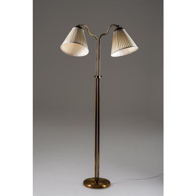 A beautifully balanced swedish floor lamp from the 1940s, executed in brass with a warm, time-softened surface. The twin...