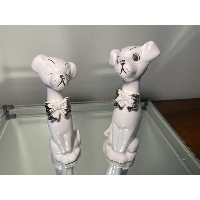 Super cool pair of mid-century modern art deco style ceramic dog figurines with bow ties and hand painted gold details....