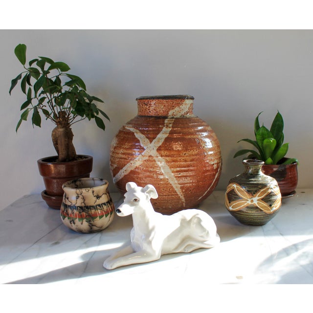 Vintage heavy studio art pottery vessel or vase in a rust and light beige color. signed on bottom by artist. Dated 99....