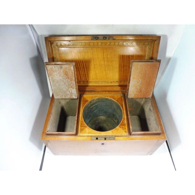 This is a classic large Marquetry inlaid English tea caddy. The piece dates back to the early 19th century.