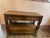 Antique carved oak or wood console/buffet table featuring decorative scrolled legs, claw feet, and open bottom shelving.