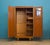 Mid-century wardrobe in teak with inset handles and tapered legs. Hanging rail to the left, shelves with pull-out tray to...