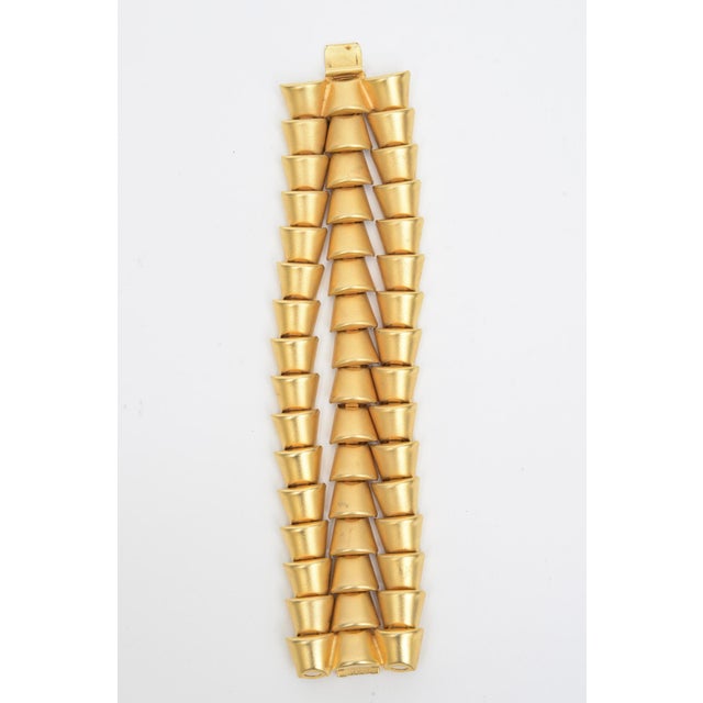This fabulous vintage gold pated sculptural bracelet of multi directional rows of inverted triangles is by Marcy Feld and...