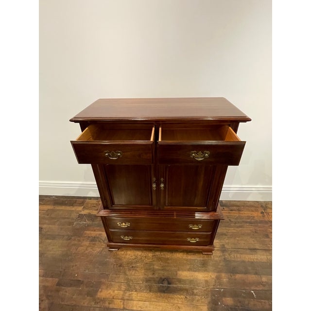 Cherrywood tall dresser or high boy. Seven drawers. Three middle drawers behind two doors. Very good original used condition.