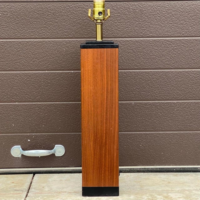 A vintage mid-century table with lamp teak wood veneer and black leather trim over a plaster core. Ships quickly via Fedex...
