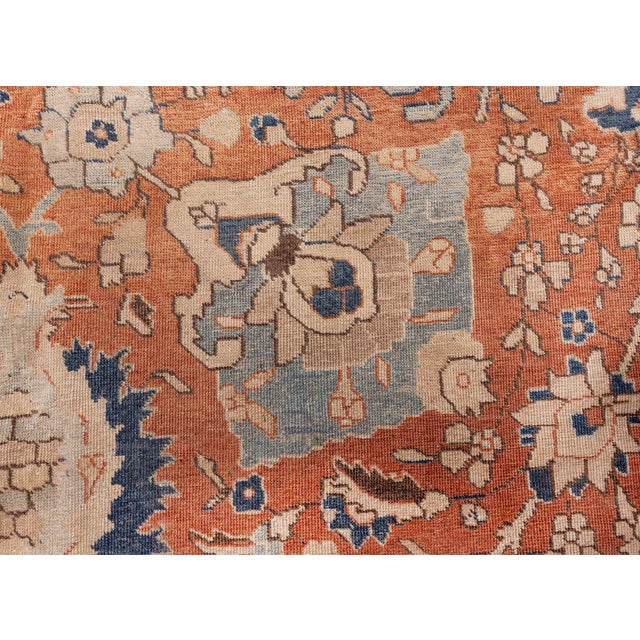 An early 20th century Persian Tabriz rug, the persimmon field with a trellis overall of enlarged stylized palmettes,...