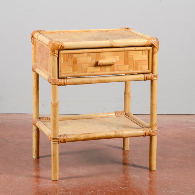 This small bamboo and wicker nightstand is a charming example of modernist and vintage design, particularly popular...
