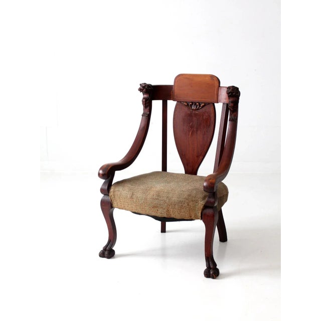 This is a rare antique 19th century arm chair. The American Empire style chair features claw feet, lion head carved...