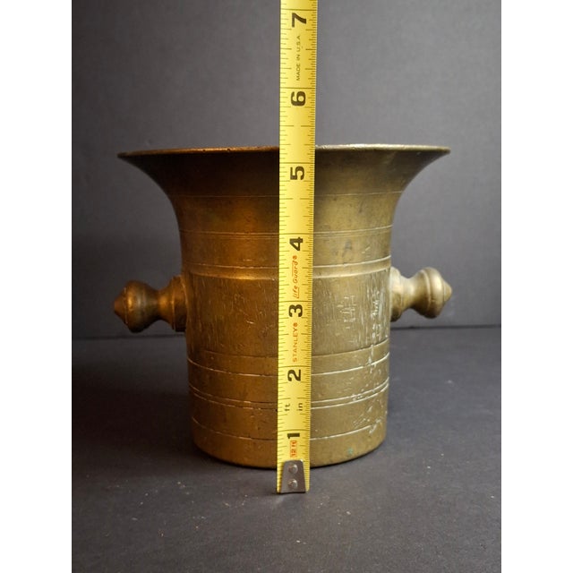 An exceptionally heavy, early antique solid brass Judaica mortar and pestle set, sourced directly from the renowned J....