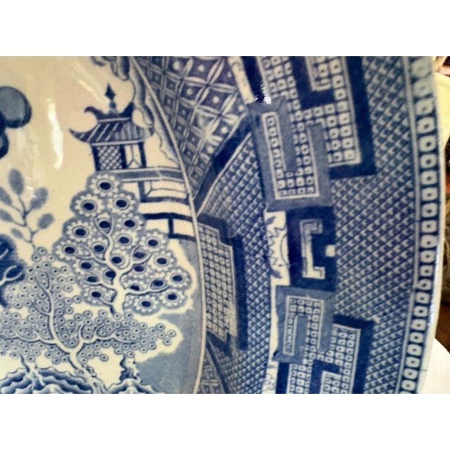 A large 19th C Staffordshire blue transfer ware meat platter in the Blue Willow pattern The piece is slightly deep to...