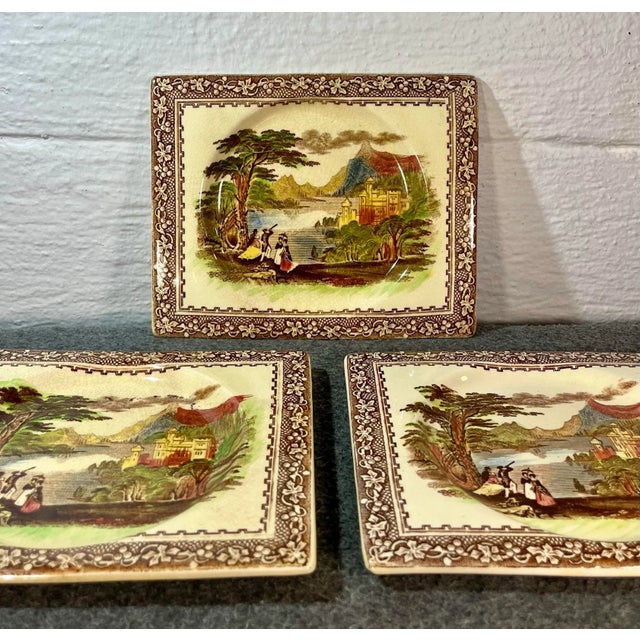 Rectangular brown multi color transferware plates depicting a vista castle scene. Marked to underside.