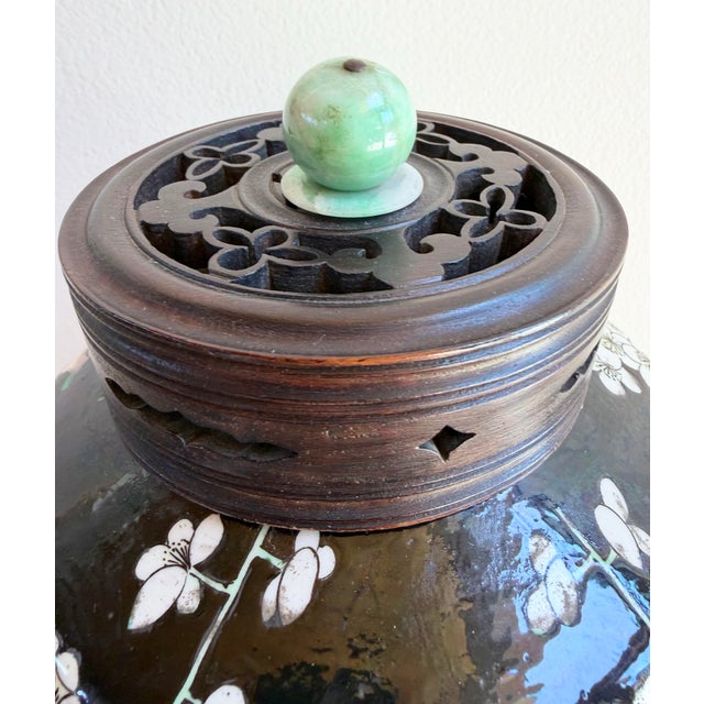 This is a beautiful Antique Chinese Famille Noir Porcelain Vase with Carved Rosewood Jade Ornament Lid. This plum blossom...