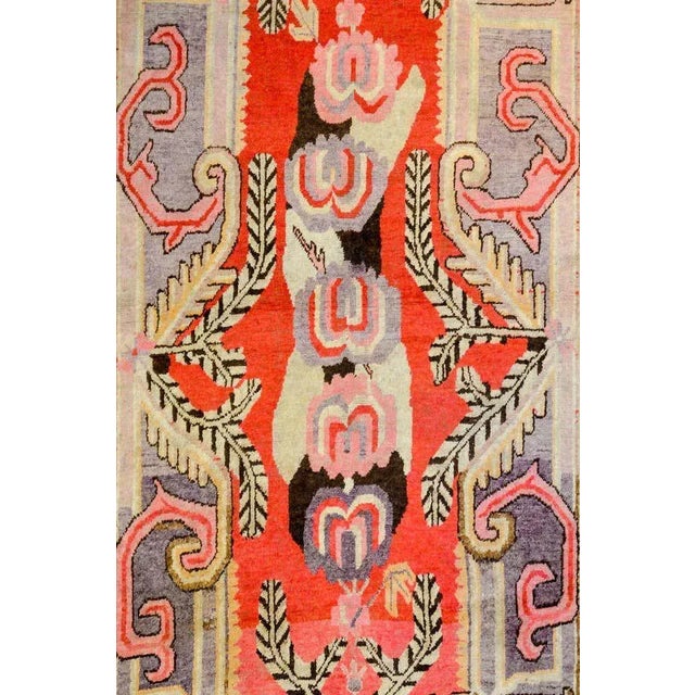 An extraordinary early 20th century Central Asian Khotan rug with an incredible asymmetrical large-scale floral medallion...