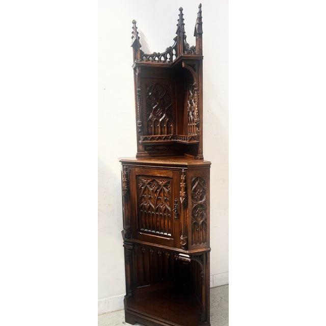 Gothic-style corner cabinet in solid oak One door in the central section One niche at the top and bottom Bearing the...