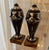 The two vase-shaped decorative objects are designed in a typical, graphic Art Deco pattern using black lacquer and silver...