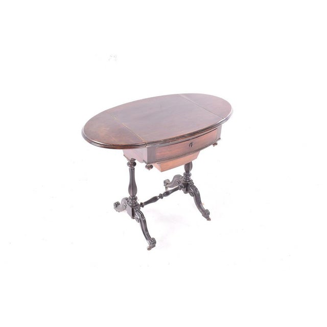 This English sewing table has flaps and basket made from mahogany.