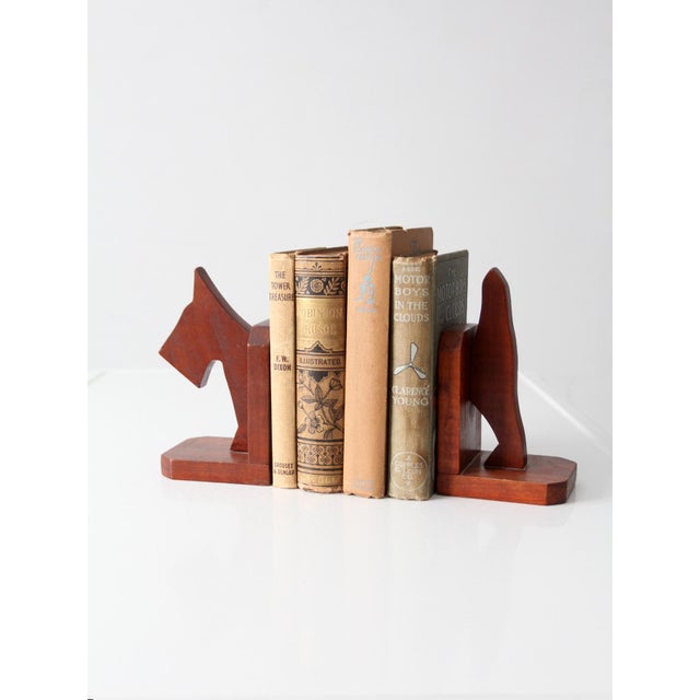 Pair of vintage carved wood bookends featuring stylized dog silhouettes, combining a playful folk art sensibility with...