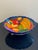 Elevate your kitchen or dining space with this stunning, generously sized fruit bowl, a vibrant testament to Mexican folk...