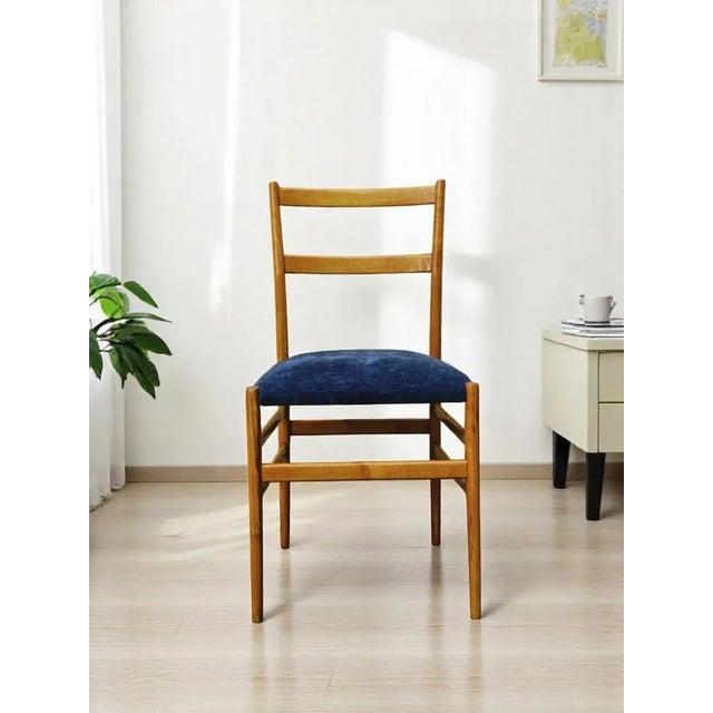 A very rare and iconic chair Mod. “646 Leggera” by Gio' Ponti, the chair is made of wood and the upholstery of blue...