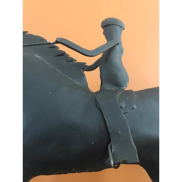 This is a vintage double-bodied metal sculpture of a horse and rider. It is masterfully crafted in a simple,...