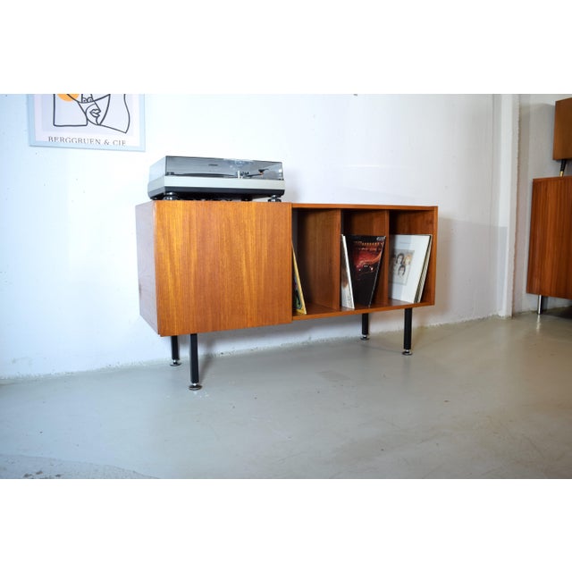 This is a beautifully designed teak sideboard for storing records or books. The cabinet was manufactured in the 1960s by...