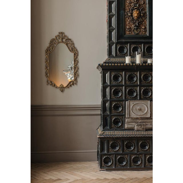 Midcentury gilded mirror designed in Italy in 1950s Elegant Neoclassical frame possibly bronze Mirror has curved, shield-...