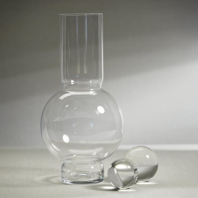 A modern, contemporary glass vase with a slender neck and robust center, suitable for flowers, or being displayed empty....