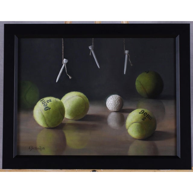 This oil on panel work presents a serene arrangement of tennis balls and a golf ball, each meticulously rendered to...